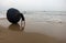 A fisherman drying his basket boat on the sea shore on a stormy day