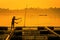 Fisherman feeds the fish in a commercial farm in Mekong river, Nongkhai. Farmers feeding fish in cages, Mekong River. The Tilapia