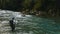 Fisherman fights a rainbow trout on caples river in new zealand