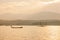 Fisherman on fishing boat in The Sirikit Dam, raft dip net and sunset sky backgrounds. Golden sun setting shines down around the