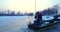 Fisherman fishing from hole in lake from his boat at winter