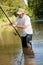 A fisherman fishing on a river