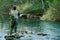 A fisherman fishing on a river