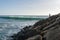 Fisherman fishing on the rock jetty at Sao Torpes Beach in Sines