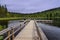 Fisherman with a fishing rod catches fish in the lake, sitting on a chair on the platform of a wooden dock