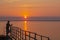 A fisherman with a fishing rod on the pier. Morning fishing