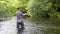 Fisherman with fishing rod on the river. Fly fishing for trout. Summer holidays and people concept