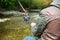 Fisherman with fly-fishing on mountain river