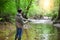 Fisherman with fly-fishing on mountain river