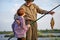 Fisherman with grandson enjoys in fishing on river. Sport, recreation, lifestyle