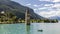 Fisherman in his boat near the submerged bell tower in Resia lake, Curon, South Tyrol, Italy