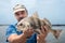 A fisherman is holding a fish black drum Pogonias cromis aga