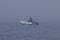 Fisherman in inflatable fishing boat with outboard motor moving in the dense fog.