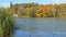 Fisherman on lake. Great beautiful autumn landscape with lake and trees.