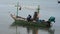 Fisherman maintenance and repair wooden fishing boat ship floating in sea ocean