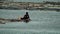 Fisherman paddles his bamboo floater raft boat on lake