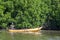 A fisherman paddles past mangroves on Pottuvil Lagoon in Sri Lanka.