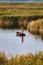 Fisherman paddling a boat on the lake in Hungary