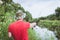 Fisherman in a panama hat and a red t-shirt casts a spinning rod