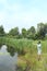 Fisherman in protective mask casting fishing rod during quarantine