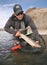 Fisherman pulling large trout out of net