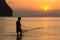 A fisherman pulls in his net at sunset on Rajamangala beach in Trang province, Thailand