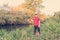 Fisherman in a red vest with a fishing rod on the shore