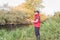 Fisherman in a red vest with a fishing rod on the shore