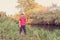 Fisherman in a red vest with a fishing rod on the shore