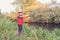 Fisherman in a red vest with a fishing rod on the shore