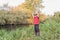 Fisherman in a red vest with a fishing rod on the shore