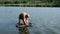 Fisherman releases the caught fish back into the river using unhooking mat. Sport carp fishing. Angler on the river