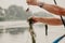 Fisherman removes algae from fishing rod on boat