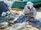 A fisherman repairs his nets on Arugam Bay beach in Sri Lanka.