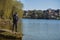 Fisherman on the riverbank catches fish and is protected from the coronavirus by wearing a mask on his face