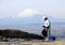 Fisherman on the rocks in the Pacific Ocean on Mount Fuji background.