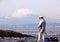 Fisherman on the rocks in the Pacific Ocean on Mount Fuji background.