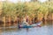 Fisherman in a rowboat, pulling in a net on the Nile River