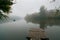 Fisherman in a rubber boat fishing with rods on a small lake, still water surface