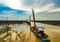 Fisherman`s boat parked at coastal mud flat at tide. Landscape of sea and beautiful blue sky and white clouds at sunset. Mud beach