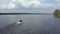 A fisherman is sailing on a boat along a wide beautiful river