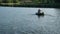 Fisherman sailing on a boat on the river. Angler carrying carp fishing tackle. Fishing hobby vacation concept