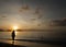 Fisherman seaching for shells on the beach during sunrise