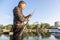 Fisherman setting fishing rod at the river bank