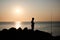 a fisherman shadow on the rocks of Punta Ballena coastline on the bay of Solanas, atlantic ocean, Maldonado, Uruguay