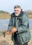 A fisherman on the shore of a lake, carp caught in the hands of a fisherman, amateur carp fishing, fishing as a hobby