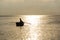 Fisherman silhouette on boat floating against reflecting sunrise, Adriatic Sea