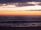 Fisherman in silhouette at dusk on beach, wide angle.