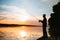 A fisherman silhouette fishing at sunset. Freshwater fishing, catch of fish.