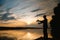 A fisherman silhouette fishing at sunset. Freshwater fishing, catch of fish.